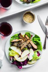 Sliced meat steak with green salad and pears