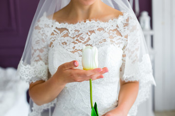 Obraz na płótnie Canvas beautiful bride holding a white flower