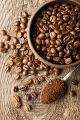 Natural ground coffee heap in transparent glass bowl on сoffee grains background