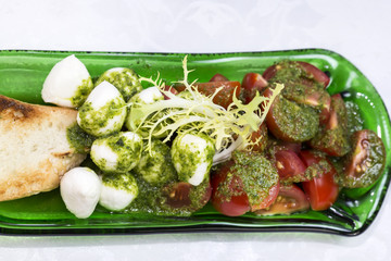 Caprese salad with tomatoes and cheese in a plate of glass