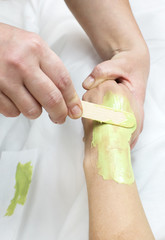 Woman in a beauty salon doing depilation