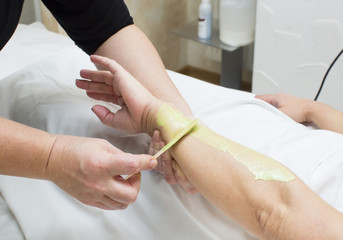 Woman in a beauty salon doing depilation