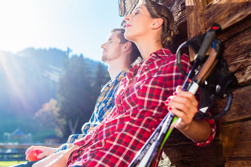 Paar macht Rast vom Nordic Walking in Berghütte