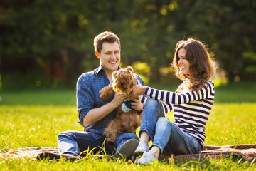 Fototapeta premium Lifestyle, happy family of two resting at a picnic in the park with a dog