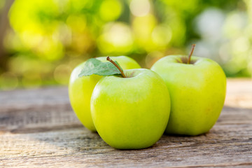 Ripe apples on wooden table, on nature background