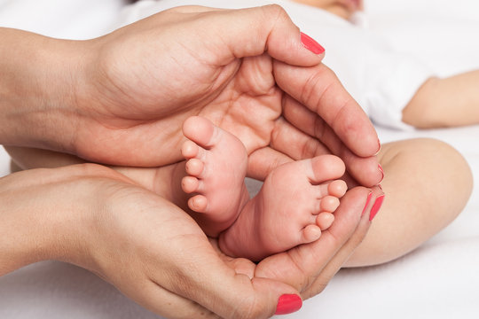 woman hands  around the baby feet