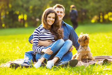 Fototapeta premium Lifestyle, happy family of two resting at a picnic in the park with a dog