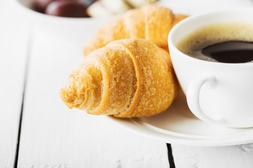 Hot cappuccino and pastries on white wooden boards