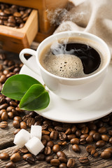 ground coffee in scoop and coffee beans on a wooden background