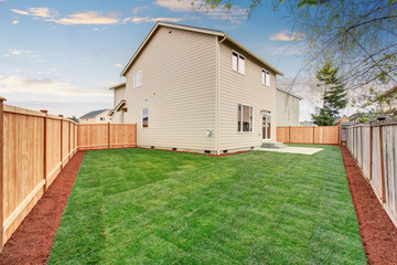 Obraz premium fenced and unfurnished back yard with grass.