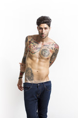 Fototapeta premium Handsome and sexy tattooed man portrait wearing blue jeans