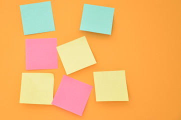 Seven sticky note spread on a bright orange wall