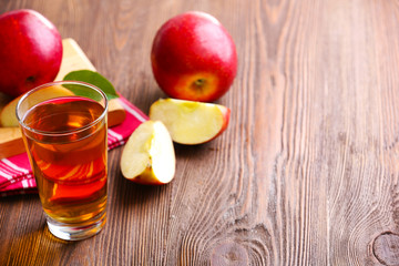 Glass of apple juice and fruits on table close up