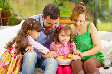 Family portrait of father, mother and two daughters sitting