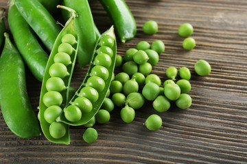 Fresh green peas on wooden table, closeup