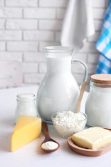 Dairy products on wooden table, on brick wall background