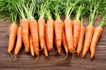 Fresh organic carrots on wooden table, closeup