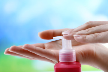 Female hands with cream on colorful blurred background