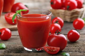 Glass of tomato juice on wooden table, closeup