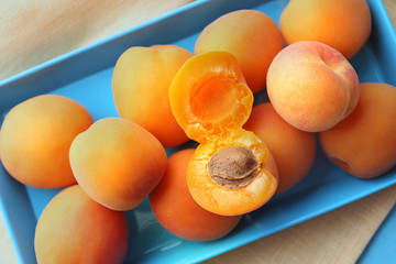Ripe apricots on metal tray on table close up