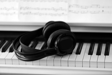 Obraz na płótnie Canvas Piano with headphones and music notes close up