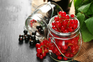 Ripe forest berries in glass jar  on wooden background