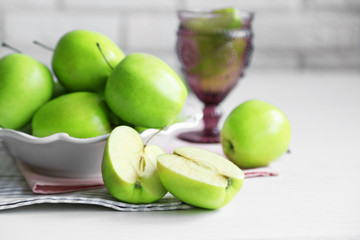 Fototapeta na wymiar Green apples in bowl on table with napkins, closeup
