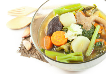 Fresh hot vegetable soup and spoon on wood