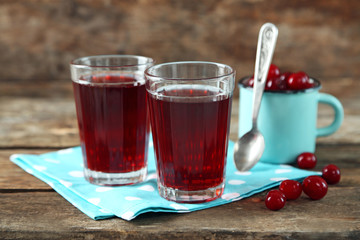 Two glasses with cherry juice on table, on light background