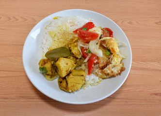 spicy salad with fried egg and chicken curry on rice