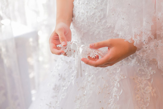 Bride's garter in woman's hands.