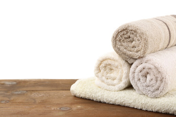 Fototapeta na wymiar Rolled bath towels on wooden table, closeup