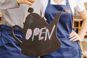 Sign open on background of workers