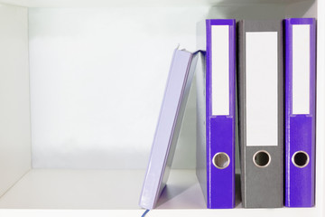 Fototapeta na wymiar Folders for documents and planner on a book shelf