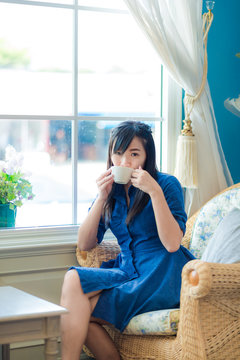 Young asian woman drinking coffee at cafe