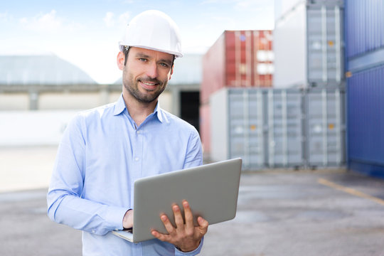 Young Attractive engineer using laptop on the dock