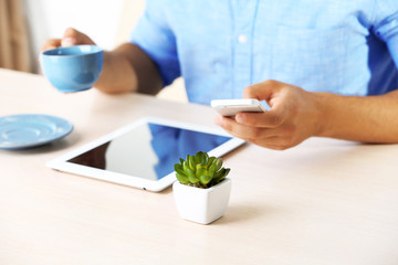 Man with digital tablet on wooden table background