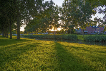 Sunset over a residential area along a canal in summer