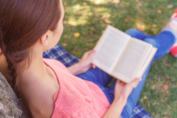 Young woman reading book in park 
