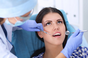 Woman dentist working at her patients teeth