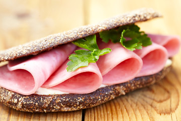 Sandwich with ham on wooden table