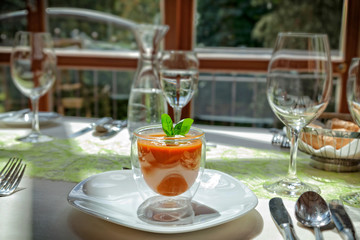 Tomatensuppe mit karamellisierten Bärlauchnocken am gedeckten Tisch Nahaufnahme