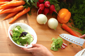 Young woman cutting vegetables in the kitchen