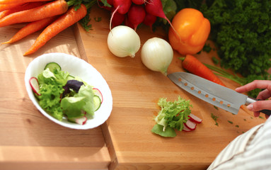 Young woman cutting vegetables in the kitchen