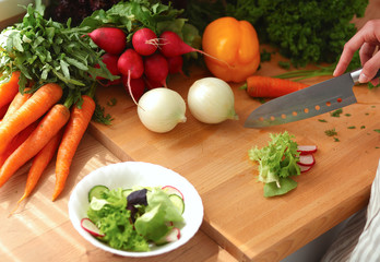 Young woman cutting vegetables in the kitchen