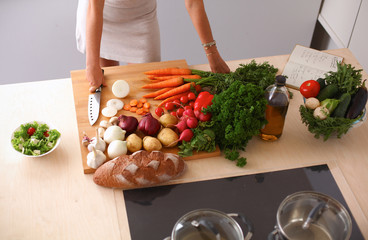 Young woman cutting vegetables in the kitchen