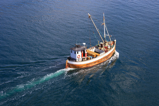 Fototapeta Old wooden fishing boat trawler on sea.