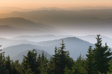 Distant mountain range and thin layer of clouds on the valleys