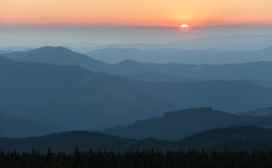 Distant mountain range and thin layer of clouds on the valleys