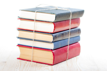 Stack of books on wooden table isolated on white background. Back to school. Copy space